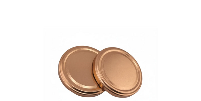 Copper twist-off jar lids, round metal caps for glass containers, on white background