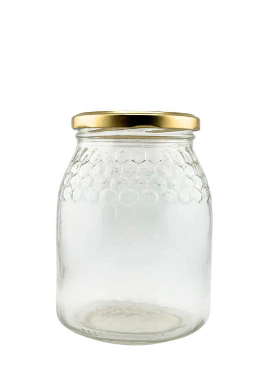Tarro de vidrio transparente con tapa dorada y diseño de panal, ideal para conservas y envases.